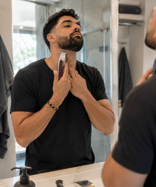 Man trimming his neckline at home using the WAHL 5-Star Cordless Detailer Li trimmer.